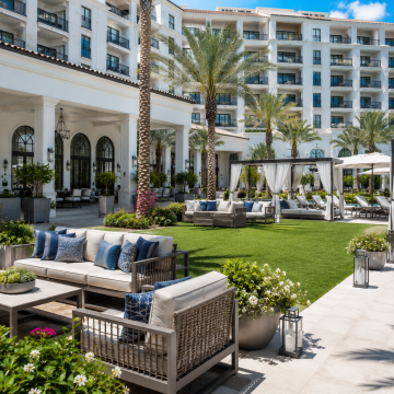 Commercial Hospitality. Artificial Grass. Sunny resort courtyard with stylish seating
